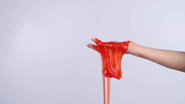 Red Slime Flowing Down From a Woman's Hand on a White Background