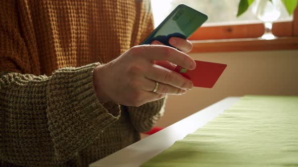 Man Paying With Phone And Credit Card In A Home or Hotel or Hostel