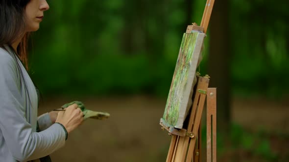 Handsome Female Drawing a Landscape on the Nature in the Forest.