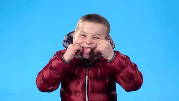 Kid Looking at Camera, Showing His Tongue and Making Faces.