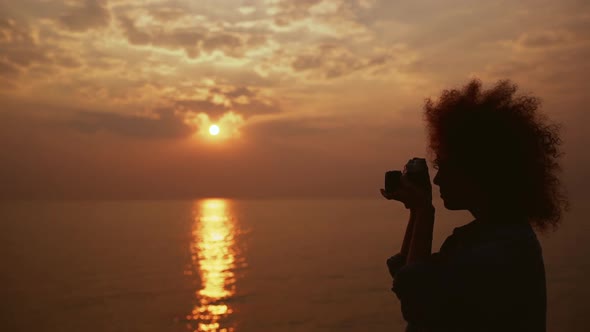 Beautiful Female Phorograph Taking Picture of Sunrise at Sea Slow Motion