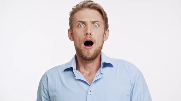 Surprised Young Bearded Caucasian Male with Blue Eyes and Brown Hair Looking at Camera with