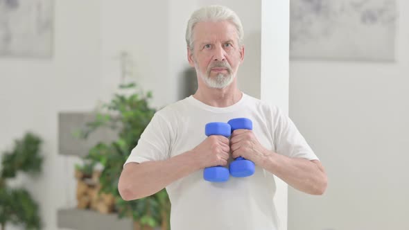 Old Man Working Out with Dumbbells at Home