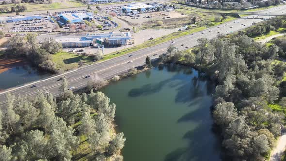 Flying over the lincoln highway and the Jedediah Smith Memorial Trail Bridge at lake natoma near Fol