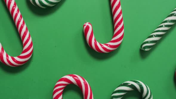 Red and green striped candy canes on green background