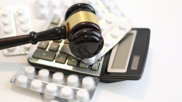 Court Gavel Calculator and Pills Rotate on a Blue Background