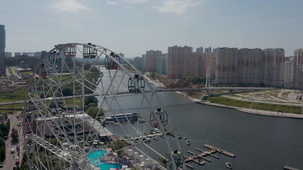 a Ferris Wheel on the River Bank with a Swimming Pool and a Beautiful Summer Landscape