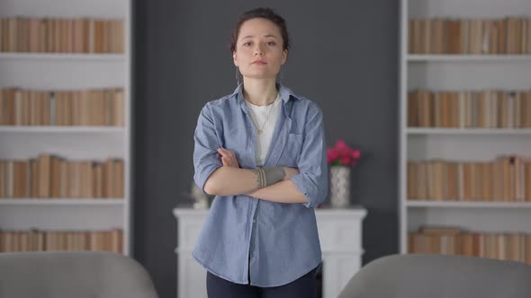 Portrait of Confident Young Serious Caucasian Woman Crossing Hands Looking at Camera