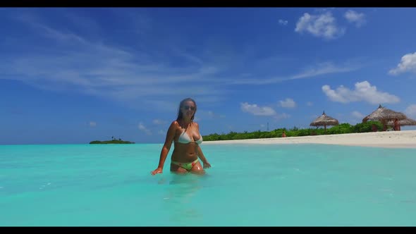 Girls posing on marine coastline beach journey by aqua blue lagoon and white sand background of the 