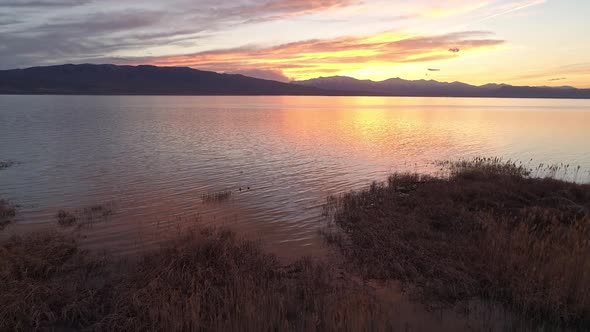 Panning along lake looking at colorful sunset