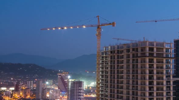 Building Construction From Day To Night. Timelapse. Tower Crane with Lighting on a Construction Site