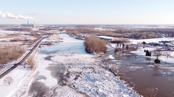 Ice Jam On The River Raisin In Monroe City, Michigan, USA  And Visible Monroe Coal Power Plant In Th