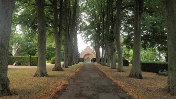 Slow motion dolly shot of a tree lined avenue with a chapel in Roskilde, Denmark