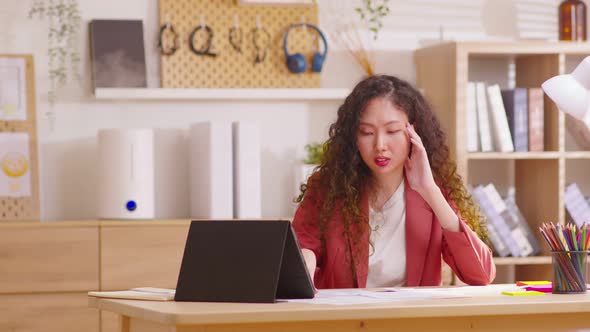 Business woman looking at tablet with stressed out in office.