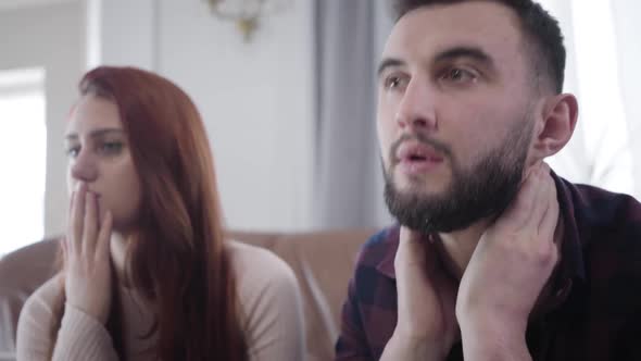 Close-up of Young Bearded Caucasian Man with Brown Eyes Touching Face Nervously As Anxious Beautiful