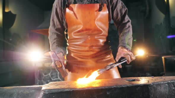 Inflamed Metal Is Getting Hammered By the Blacksmith. Slow Motion.
