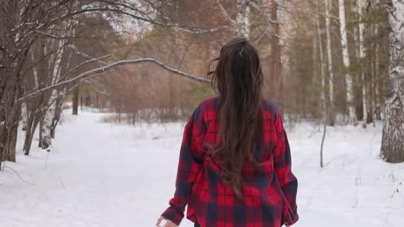 Female in Checkered Shirt Walking in Snowy Park