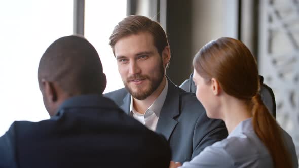 Smiling boss listening to subordinate talking