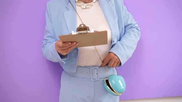 Woman in a Stylish Suit Holds a Tablet, Photo Without a Face