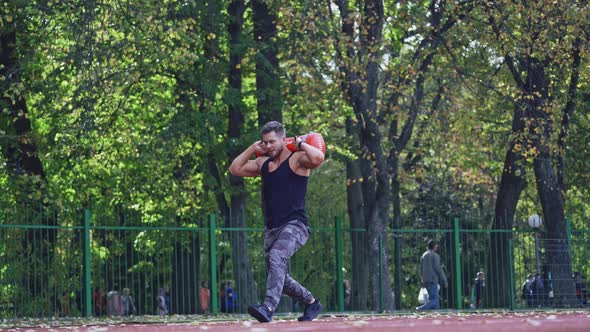 Man training at stadium. Fit athlete doing exercises at stadium