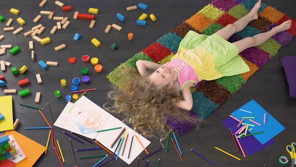 Curly Blond Child Lying on the Carpet Dreaming and Laughing, Happy Childhood