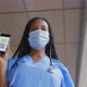 Low Angle View of Afro Female Doctor in Medical Mask Show Digital Vaccinated Passport on Smartphone - VideoHive Item for Sale