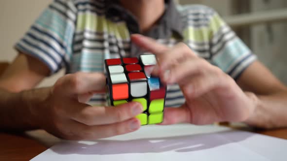 Man Solving Rubik's Cube - close up, selective focus
