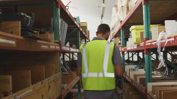 Worker walking between two shelves