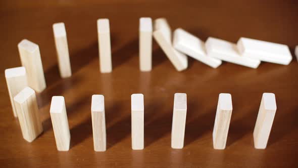 Close Up Row White Dominoes Falling on Wooden Surface. Concept Business Crash, Bankruptcy, Falling