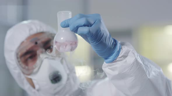 Scientist Looking at Gas Coming out of Flask