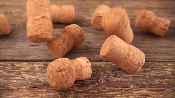 Wine corks from champagne falling onto an old wooden board. Slow motion.