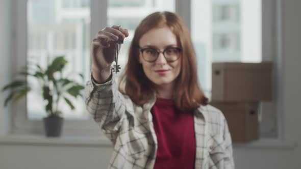 Girl with Glasses Showing Off the Keys to the Apartment