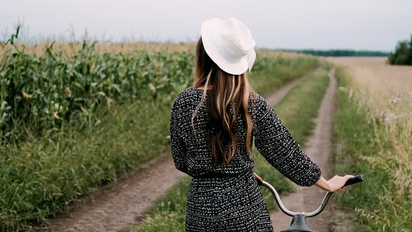 Beautiful Girl Rides An Old Bicycle Through Village Field