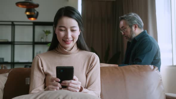 asian attractive female wife hand hold smartphone on sofa