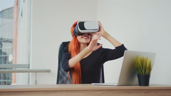 Young Pretty Red-haired Woman Wearing VR Glasses. The Woman Is in Virtual Reality Thanks To VR