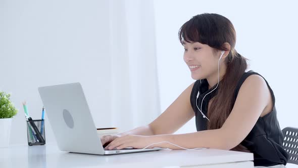 Young asian woman smiling say hello using chat social network with video call on laptop computer.