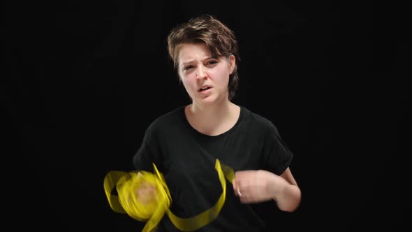 Serious Young Woman Taking Off Ropes Releasing From Slavery or Tyranny