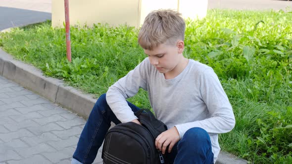 Schoolboy Takes Bottle Out of His School Backpack and Drinks Water