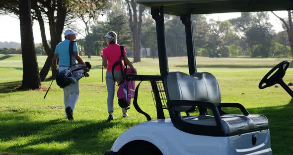 Two golfers walking together with golf bag
