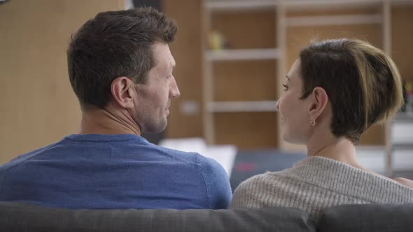 Happy Loving Man and Woman Sitting on Couch Looking at Each Other Putting Heads Together