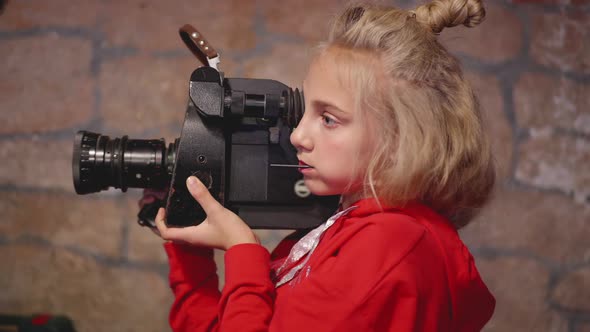 Young Girl Cinematographer Using Retro Camcorder for Shooting Video in Brick Studio, Teenager Girl