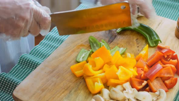 The Chef Cuts Green and Hot Peppers with a Professional Knife