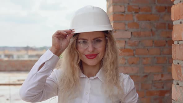 Female Architect in Business Attire Stands at the Construction Site