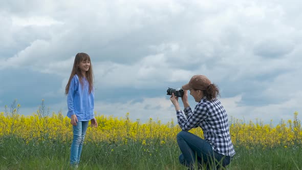A woman photographs a child in nature. 