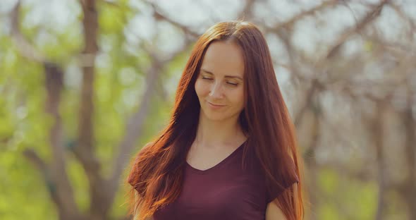 Happy Young Woman Walks on a Sunny Day in Spring