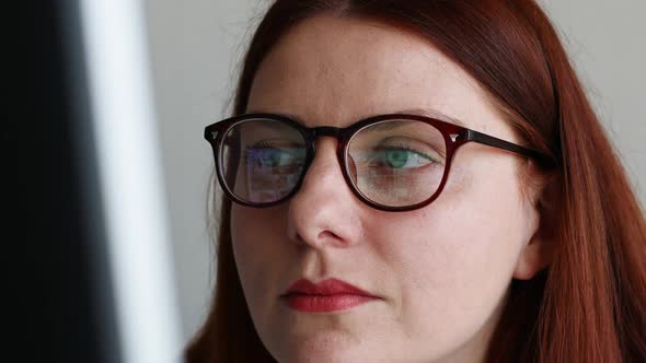 Beautiful Caucasian Student Looking at Computer Screen Watching Webinar or Doing Video Chat By