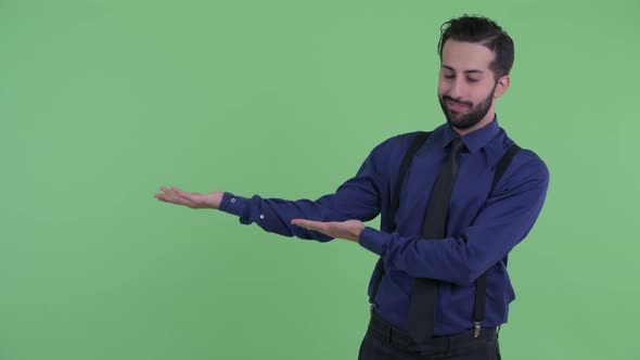 Stressed Young Bearded Persian Businessman Showing Something