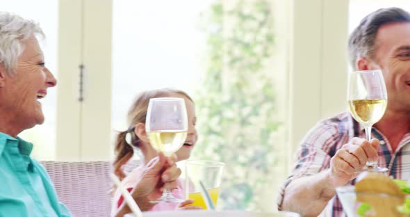 Family toasting a glasses of wine and juice on dining table