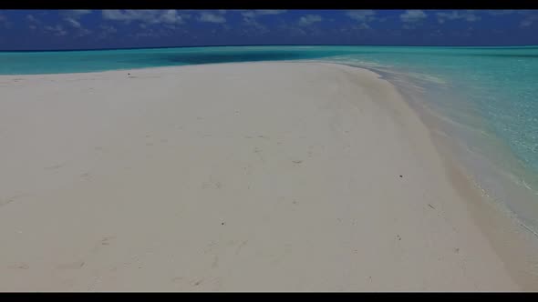 Aerial drone shot scenery of marine seashore beach trip by blue green ocean with clean sandy backgro