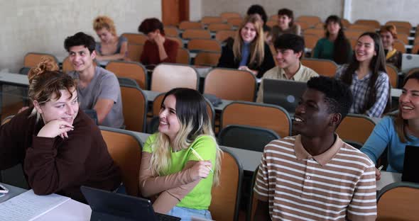 Multiracial students working with laptop computers inside classroom at school university